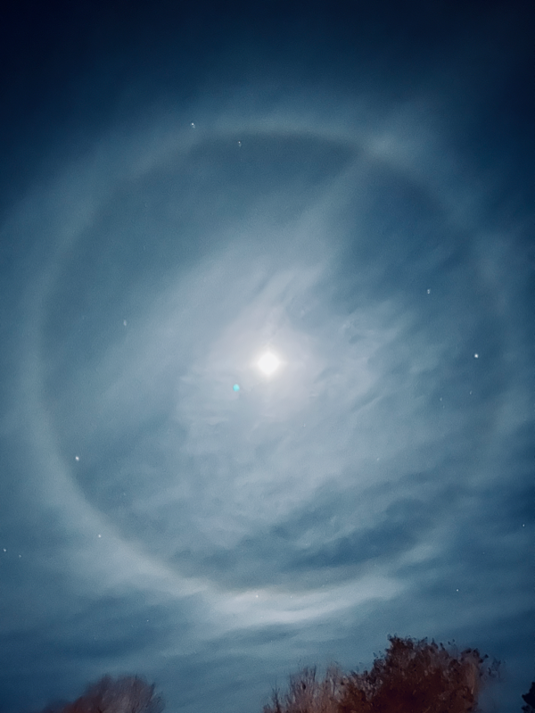 A 22-degree halo or winter halo around the moon.